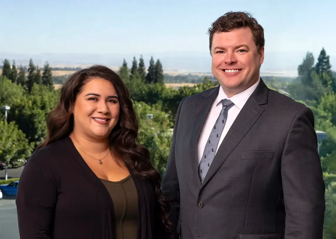 Attorney Matthew J. Wilkins and a colleague smiling, with Central Valley hills behind them